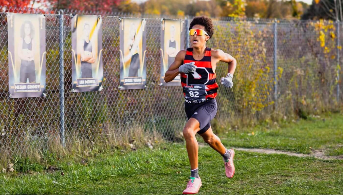 Powers Catholic Cross track runner wearing Blue Star Sports Apparel uniform